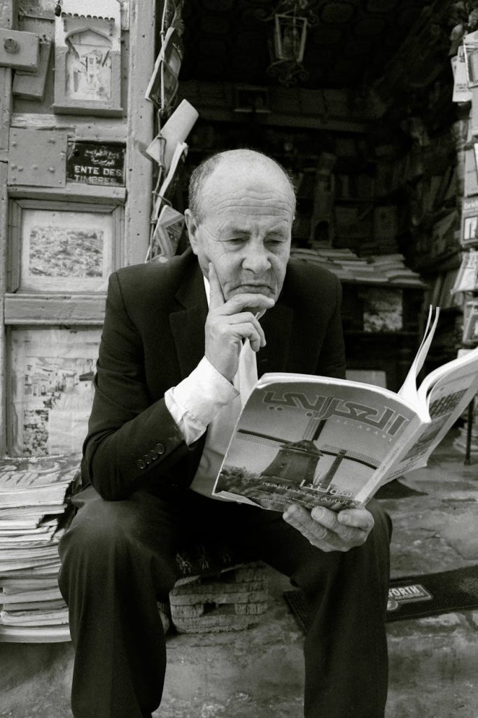 elderly man reading magazine in chefchaouen