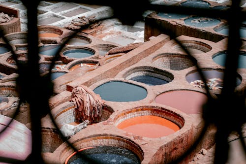 Free Aerial view of colorful dyeing vats in a traditional Moroccan leather tannery, vibrant textile scene. Stock Photo