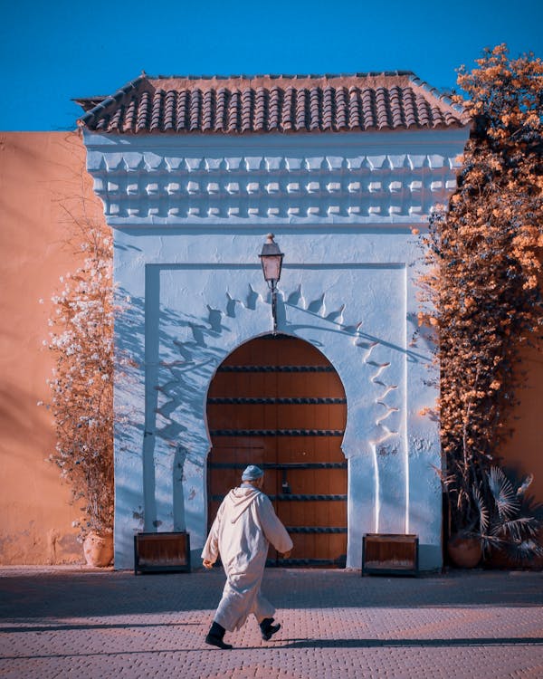 Free Photo Of Man In Traditional Clothing Walking By Koutoubia Mosque In Morocco