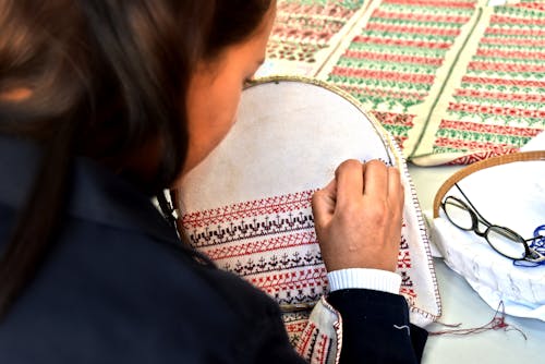 Free A woman skillfully hand-embroiders intricate patterns in a Fès, Morocco workshop. Stock Photo
