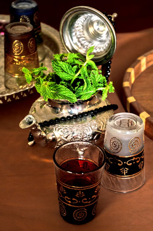 Free Elegant arrangement of traditional Moroccan mint tea with ornate glasses and teapot. Stock Photo