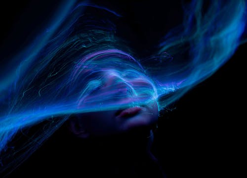 Free Dynamic portrait with swirling neon lights creating an ethereal and futuristic vibe. Stock Photo