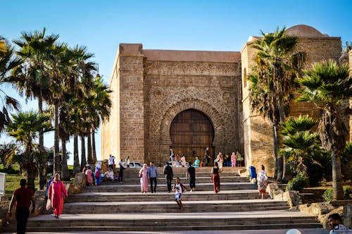 Free Tourists at Bab Oudaia Gate, Rabat, enjoying a sunny day by the iconic landmark. Stock Photo
