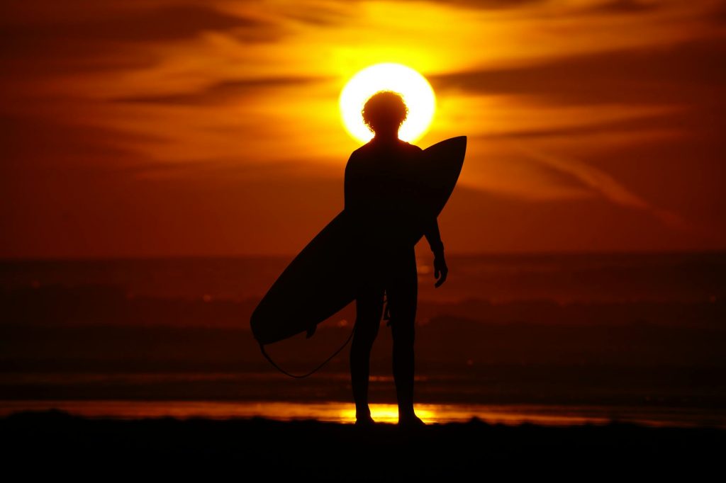 silhouette of surfer at sunset in taghazout
