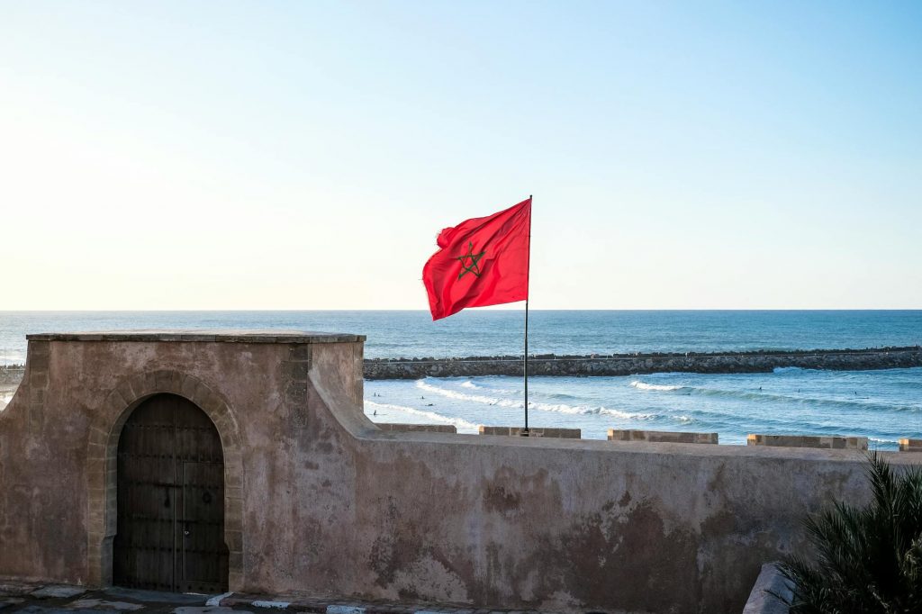 moroccan flag waves over coastal fortification