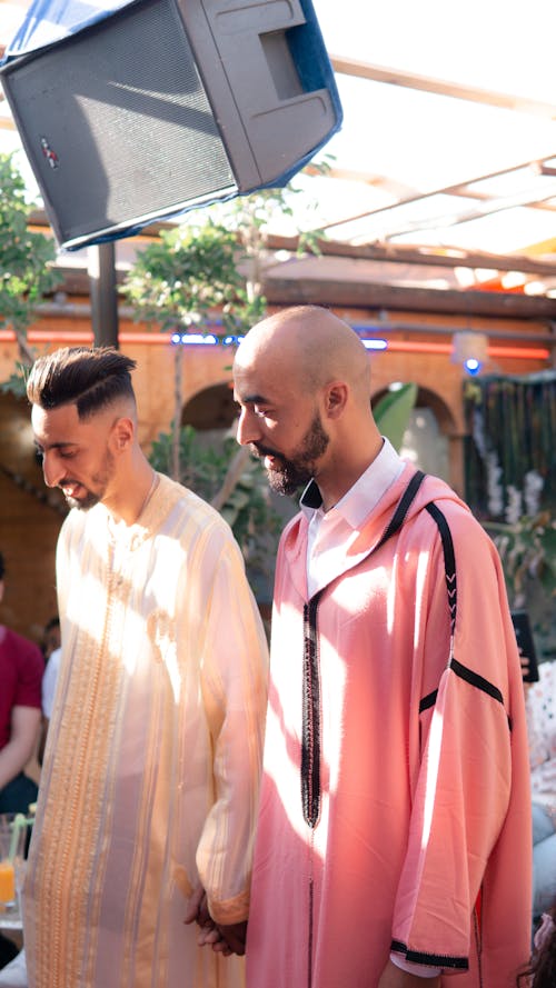 Free Two men in traditional Moroccan attire celebrating a cultural ceremony outdoors in Fes, Morocco. Stock Photo