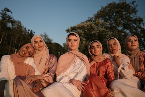 Free A group of women wearing traditional hijabs enjoying the outdoors at sunset. Stock Photo