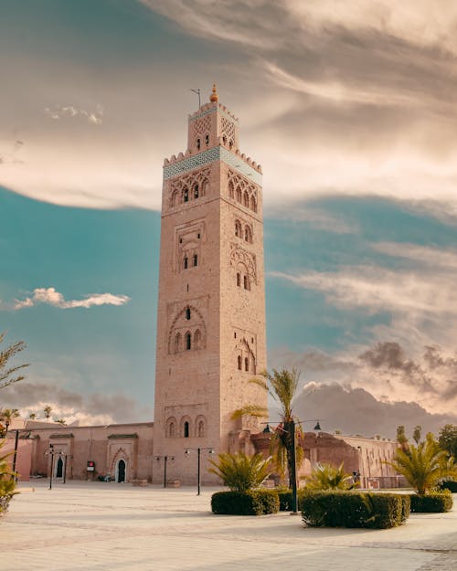 Free Majestic view of the Koutoubia Mosque tower, a landmark in Marrakech, Morocco under a dramatic sky. Stock Photo