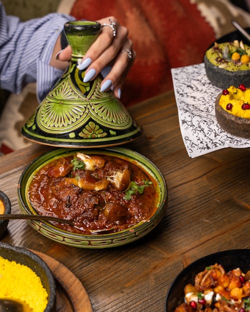 Free Vibrant Moroccan meal with tagine, couscous, and colorful sides, highlighting cultural richness. Stock Photo
