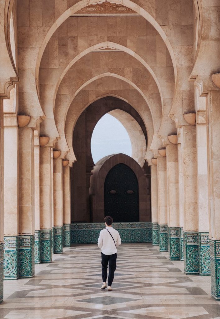 back view of a man walking through a mosque in casablanca