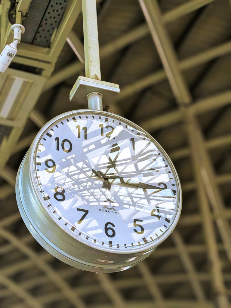 vintage clock in train station with structural reflections