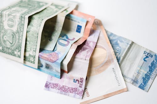 Free A collection of different international currency notes, including US Dollar, Euro, and Brazilian Real, on a white background. Stock Photo