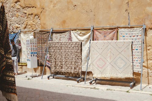 Free Traditional Moroccan rugs on display against an ancient wall in El Jadida, Morocco. Stock Photo