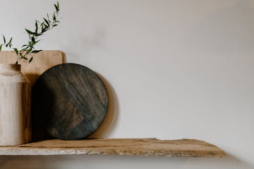 Free Elegant minimalist arrangement of wooden decor pieces and vase on a wooden shelf. Stock Photo