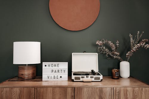 Free A modern interior setup featuring a vinyl record player, lamp, and decor elements, perfect for a cozy home vibe. Stock Photo